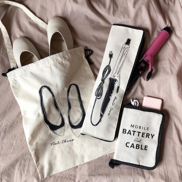 the contents of a cell phone case and bag are laid out on a bed next to each other