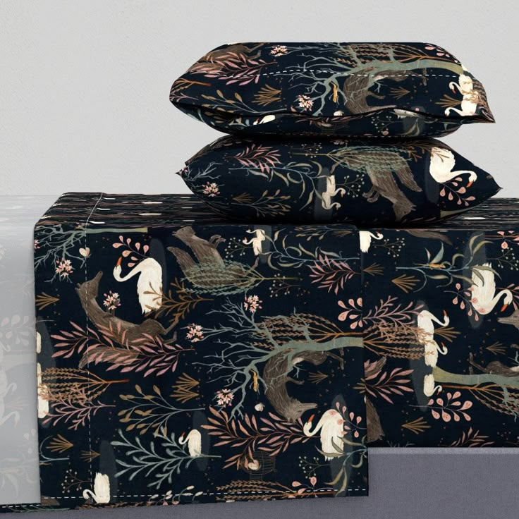 three pillows stacked on top of each other in front of a gray background with floral designs