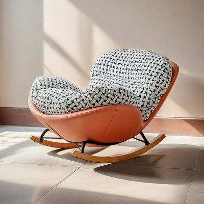 a rocking chair with a black and white patterned seat cover sitting on the floor in front of a window