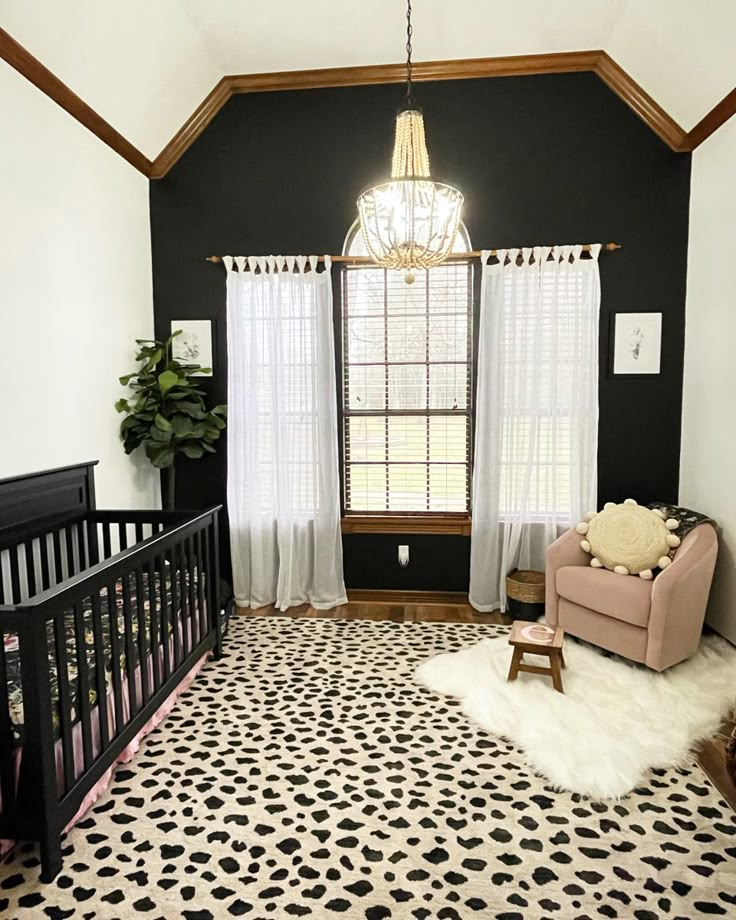 a baby's room with black walls, white curtains and a leopard print rug