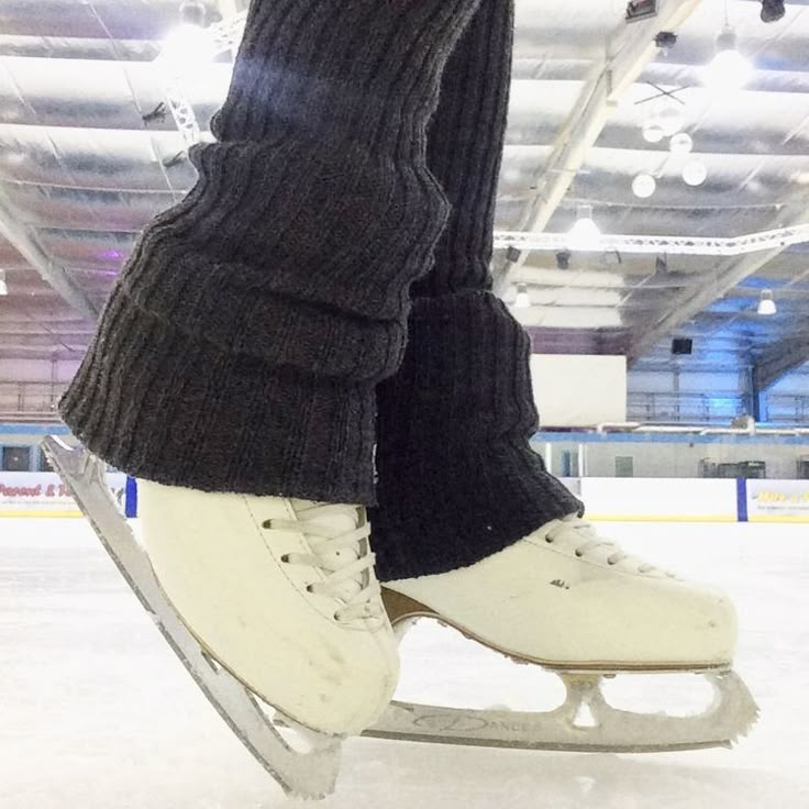 the legs and feet of a person on an ice skates in a skating rink