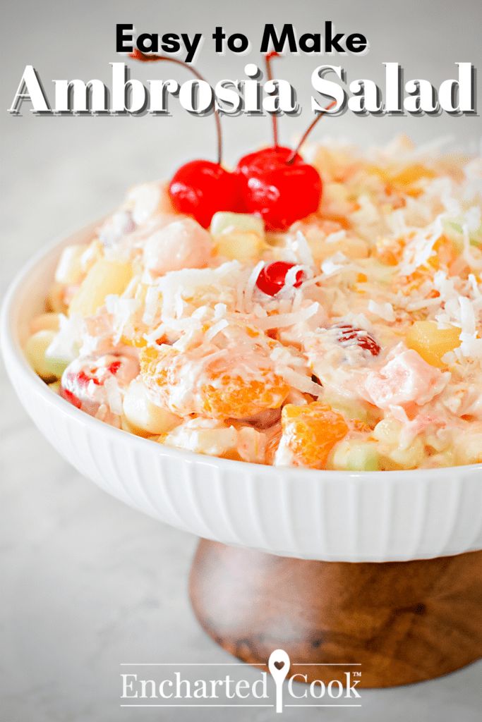 a white bowl filled with fruit salad on top of a wooden table and text overlay reads easy to make ambrosia salad