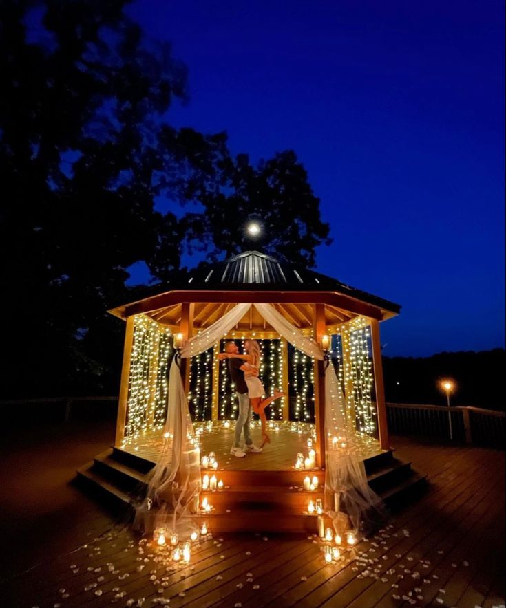 a gazebo decorated with fairy lights at night