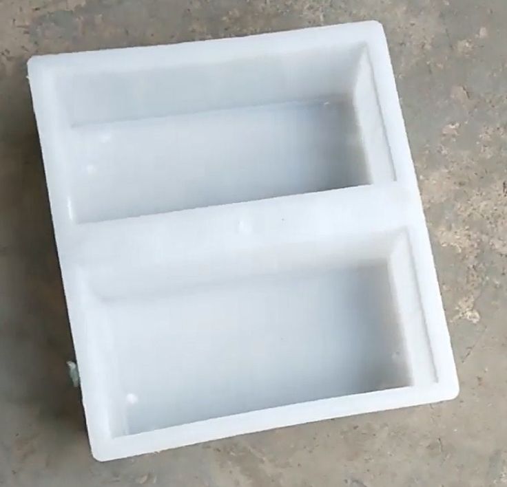 an empty white container sitting on top of a cement floor