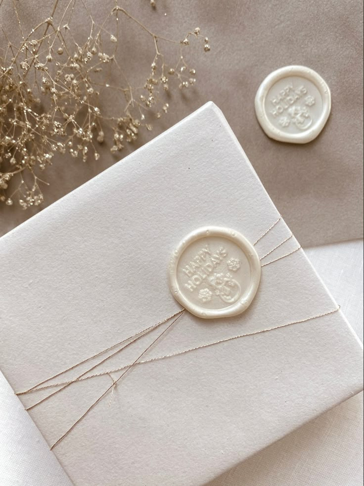 two wax seals on top of a white envelope