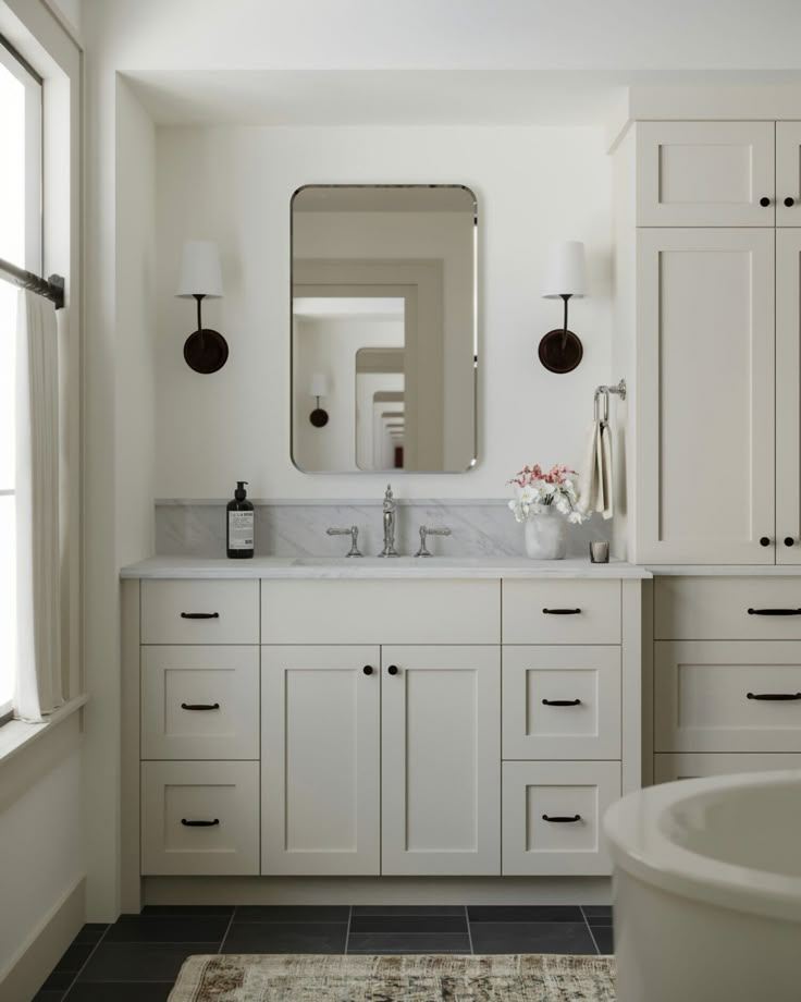 a white bathroom with two sinks and a bathtub