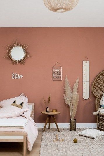 a bedroom with pink walls, wicker furniture and white rugs on the floor