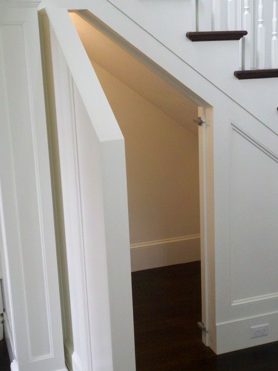 an open door leading up to a stair case in a room with white walls and wooden floors