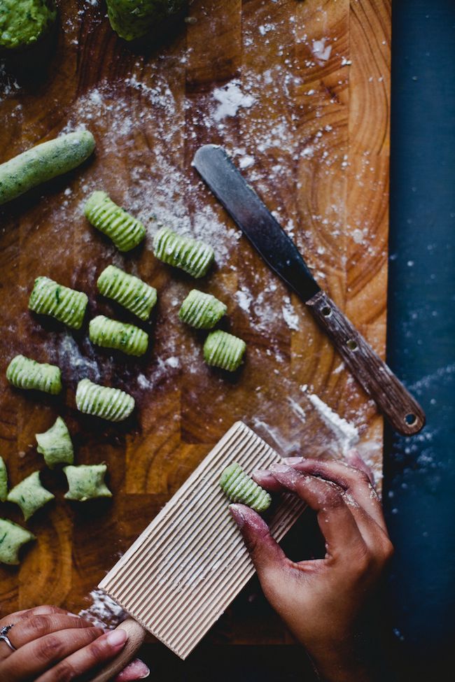 someone is peeling cucumbers on a cutting board with a knife and other ingredients