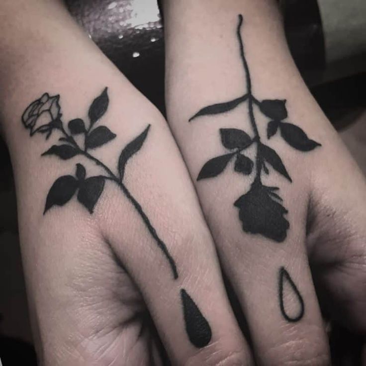 two matching tattoos on their hands with flowers