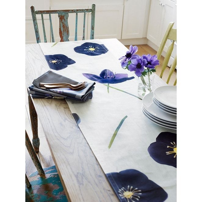 a table with blue flowers on it and place settings in front of the dining room table