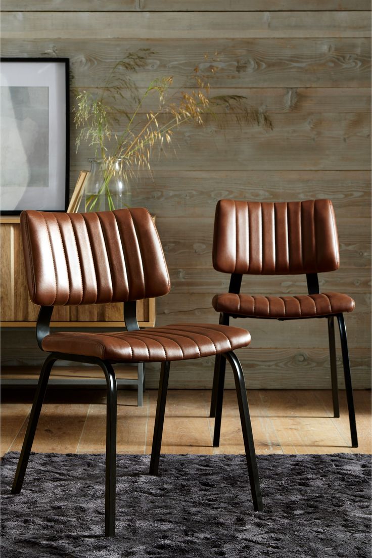 two brown leather chairs sitting next to each other