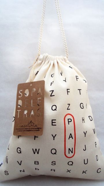 a white bag with red letters on it and a brown tag hanging from the front