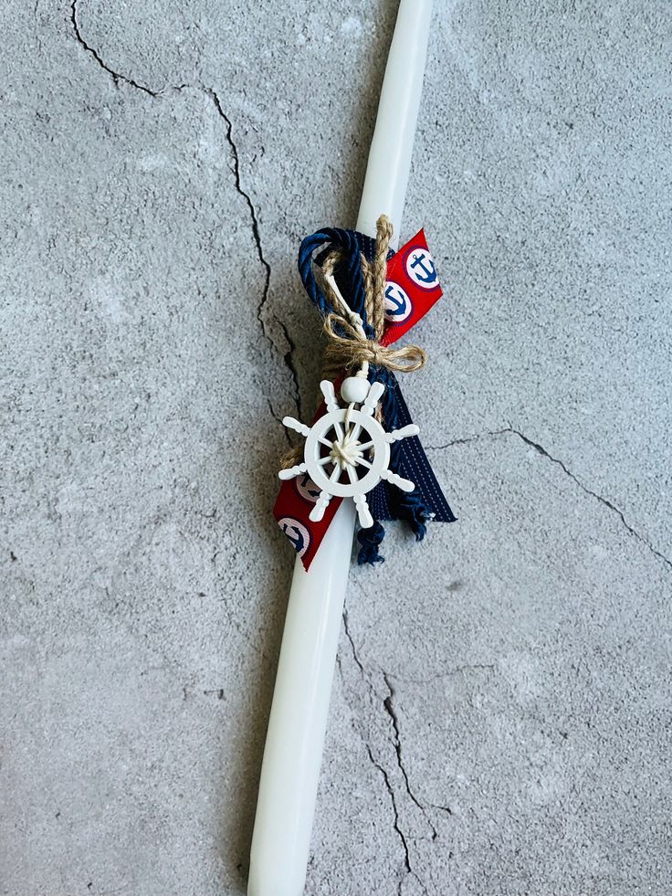 a white candle with red, white and blue decorations on it sitting on the ground