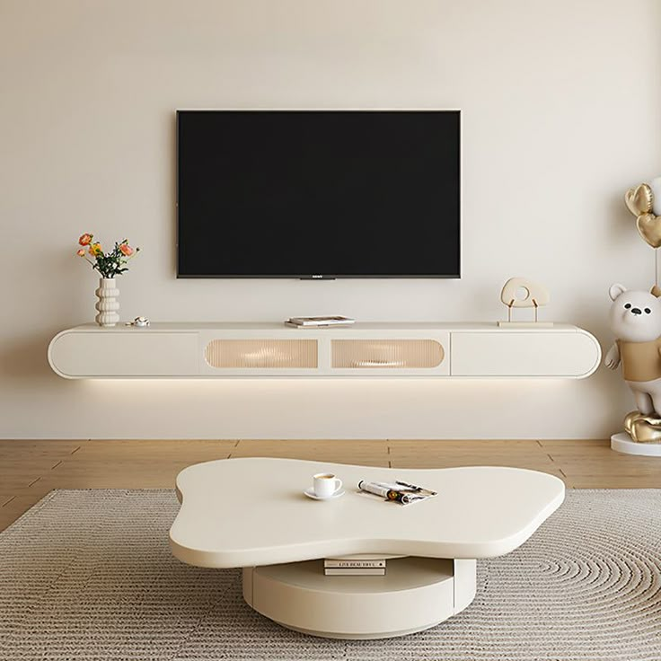 a living room with a large flat screen tv mounted on the wall above it's entertainment center