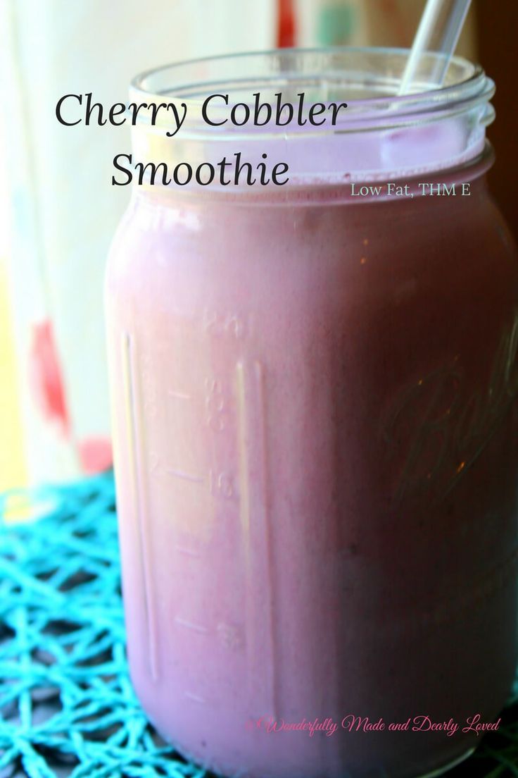 a pink smoothie in a mason jar with a straw