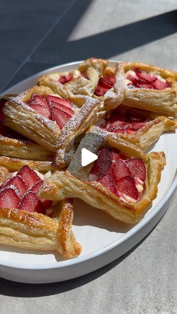 a white plate topped with pastries covered in powdered sugar on top of a table