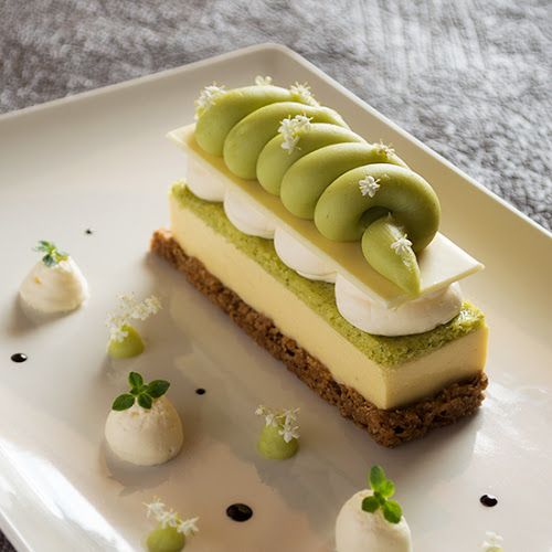 there is a piece of cake on the plate with white and green decorations around it