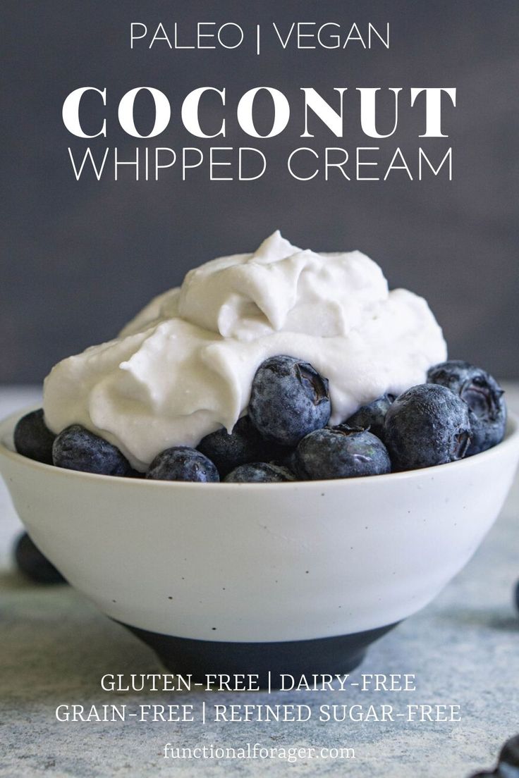 a bowl filled with blueberries and whipped cream on top of a table next to chocolate chips