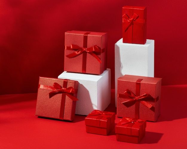 three white boxes with red bows are stacked next to each other on a red background