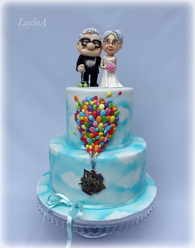 a wedding cake with an image of a couple on top and balloons in the shape of a heart