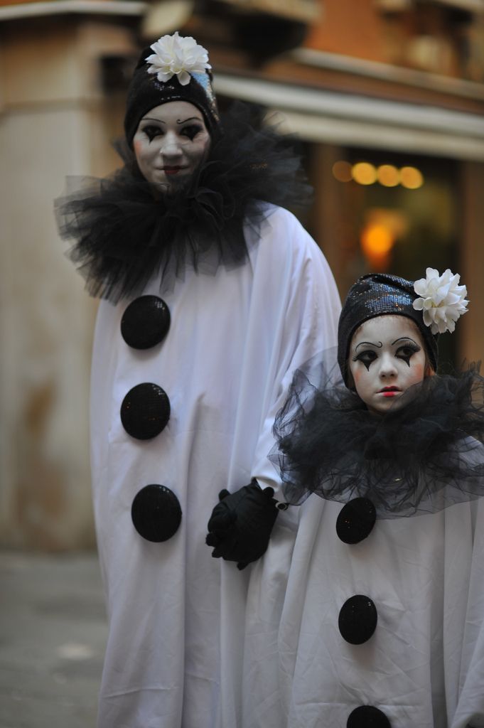 two people dressed in white and black costumes