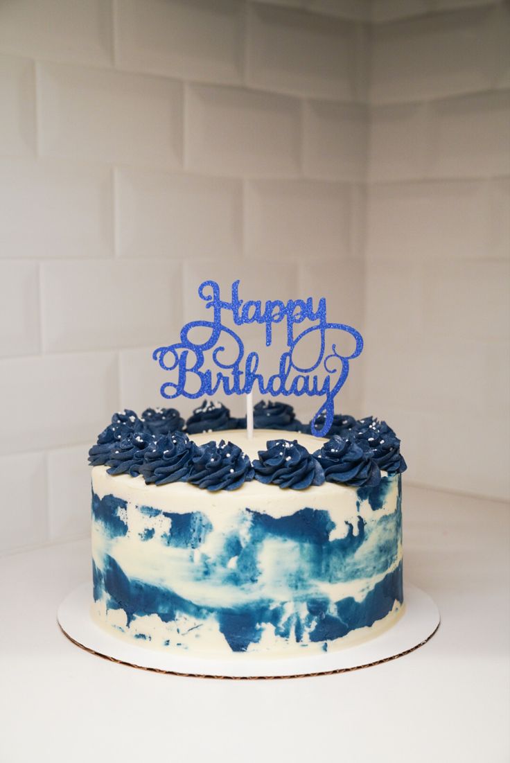 a blue and white cake with the words happy birthday on it