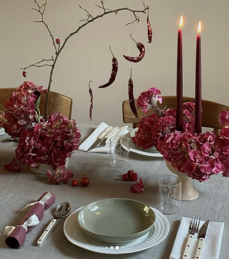 the table is set with pink flowers and candles