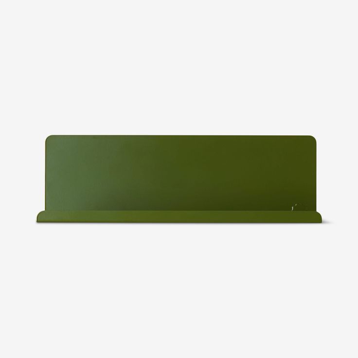 a green shelf sitting on top of a white wall