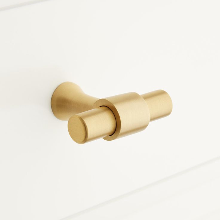 an image of a brass door handle on a white cabinet