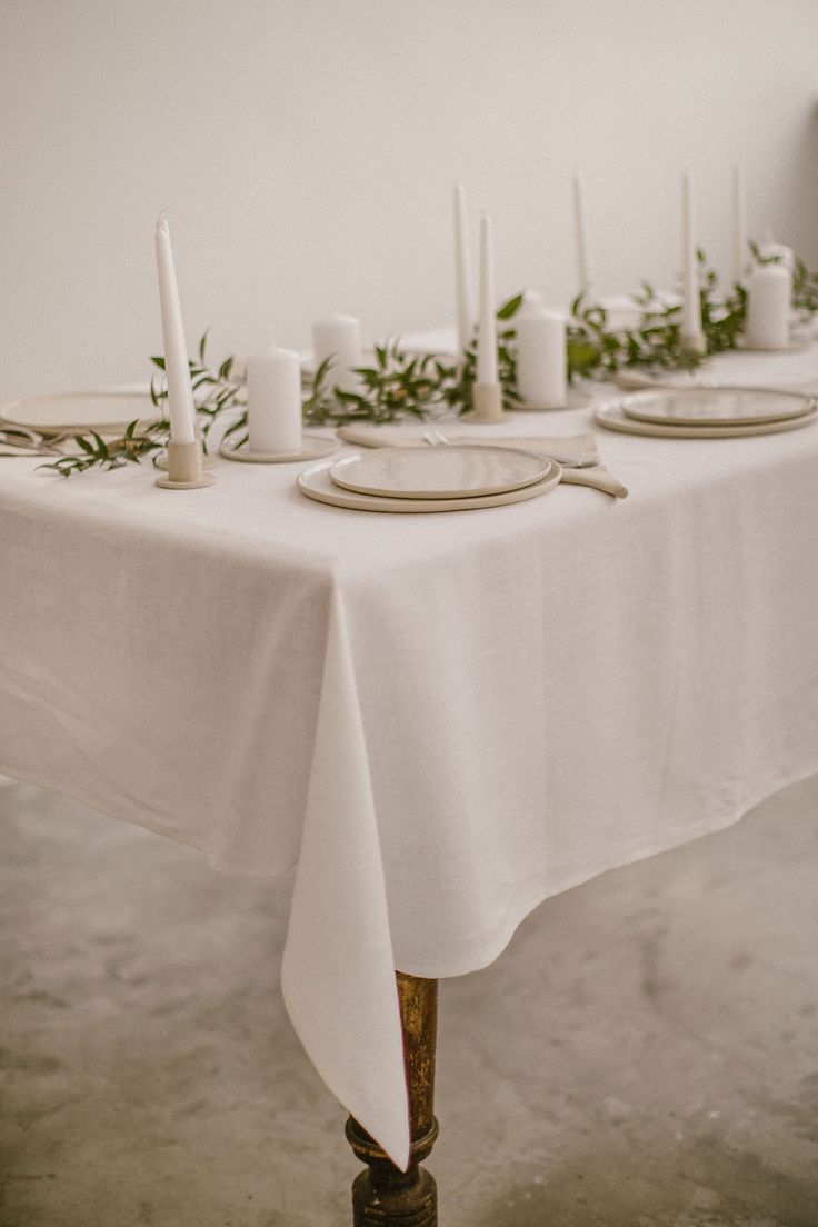 the table is set with candles and plates