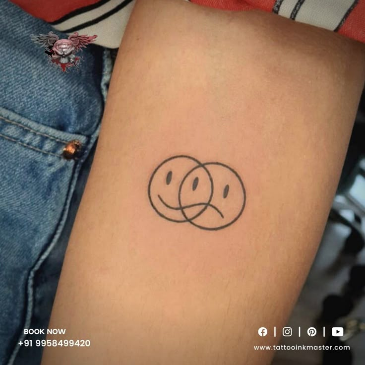 a person with a smiley face tattoo on their arm