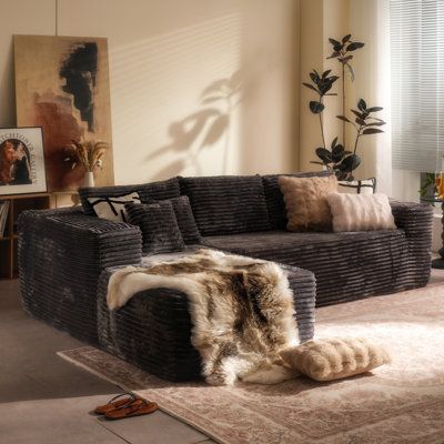 a living room filled with furniture and lots of pillows on top of carpeted flooring