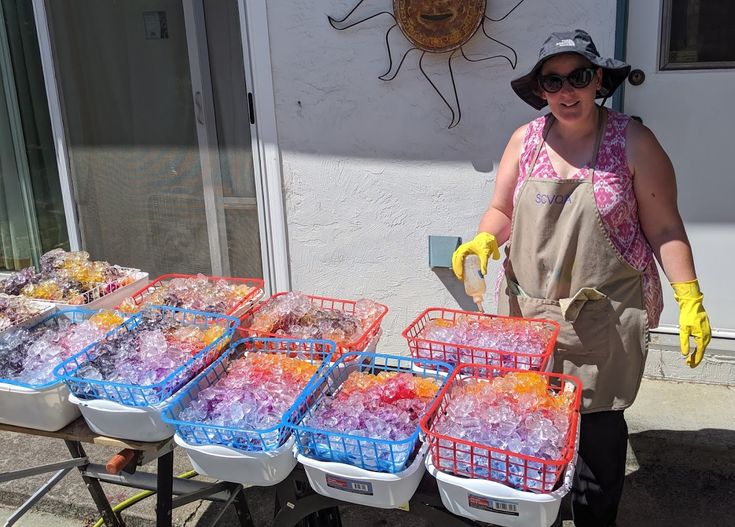 a woman standing in front of a table filled with plastic containers