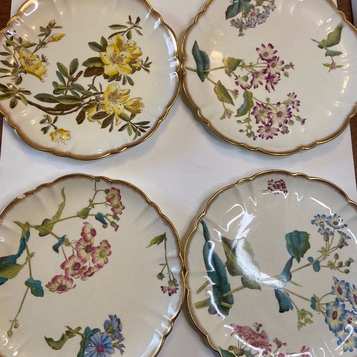 four plates with birds and flowers painted on them