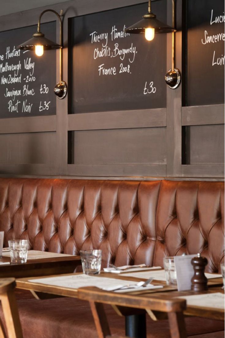 an instagram photo of a restaurant with menus on the wall and leather booths