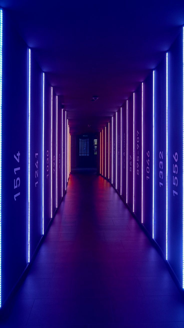 an empty hallway with neon lights on both sides