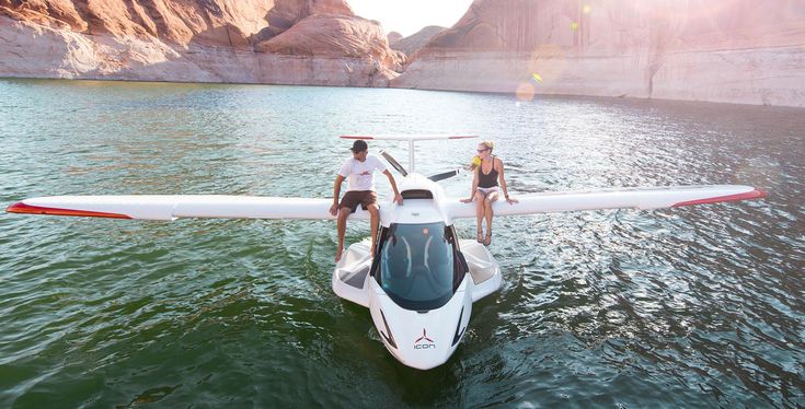 two people standing on the front of a small boat