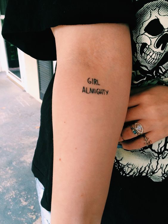 a woman with a tattoo on her arm that says girl almighty in black ink