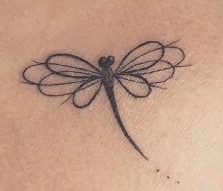 a small dragonfly tattoo on the chest