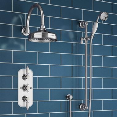 a blue tiled bathroom with shower head and handset