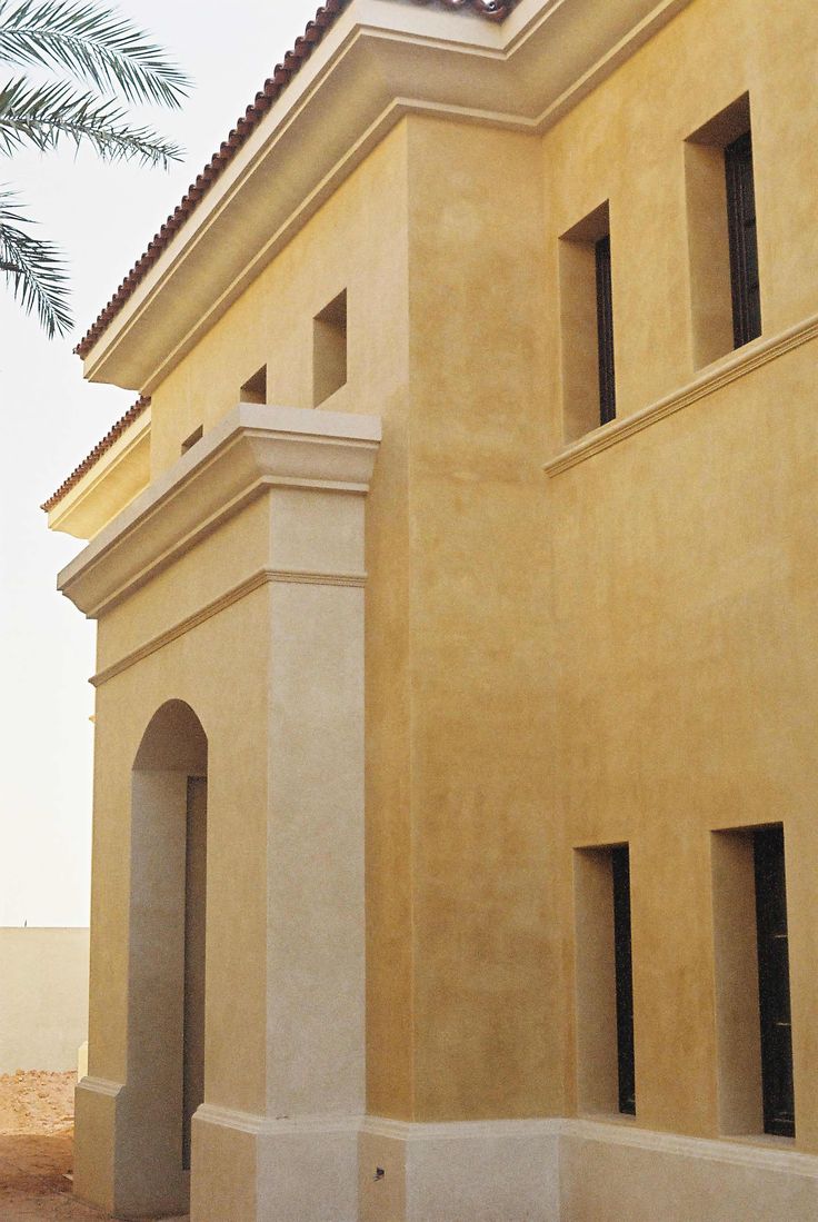 a building with a clock on the top of it's roof and palm trees in the background