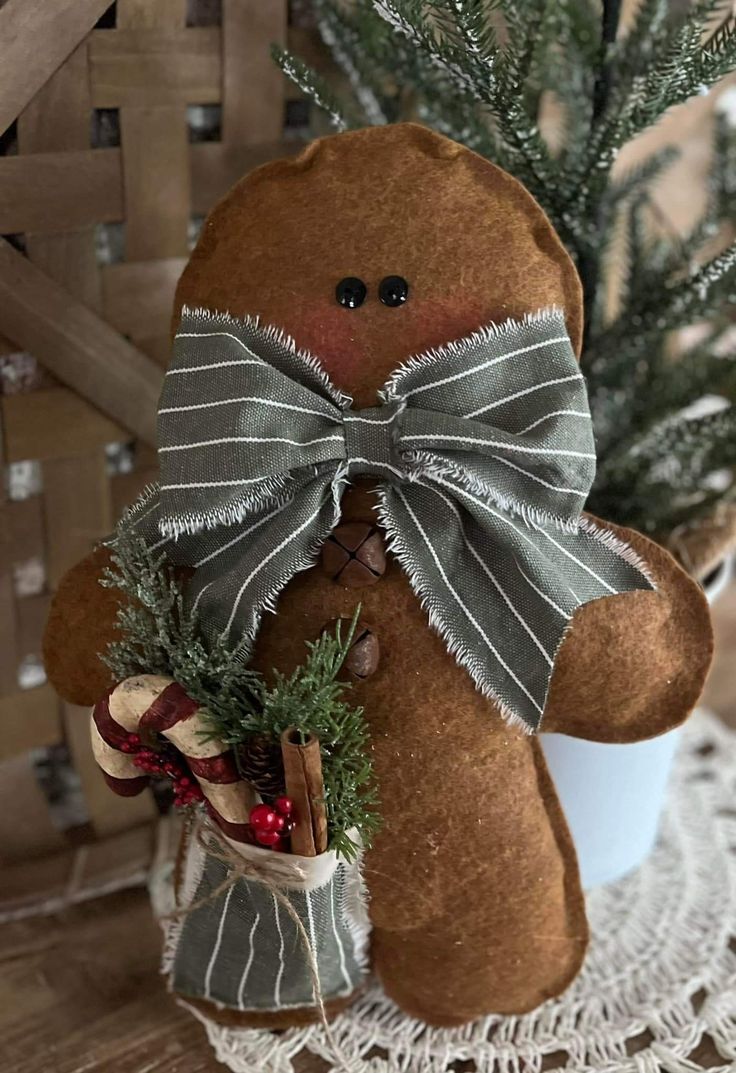 a brown teddy bear sitting next to a potted plant on top of a table