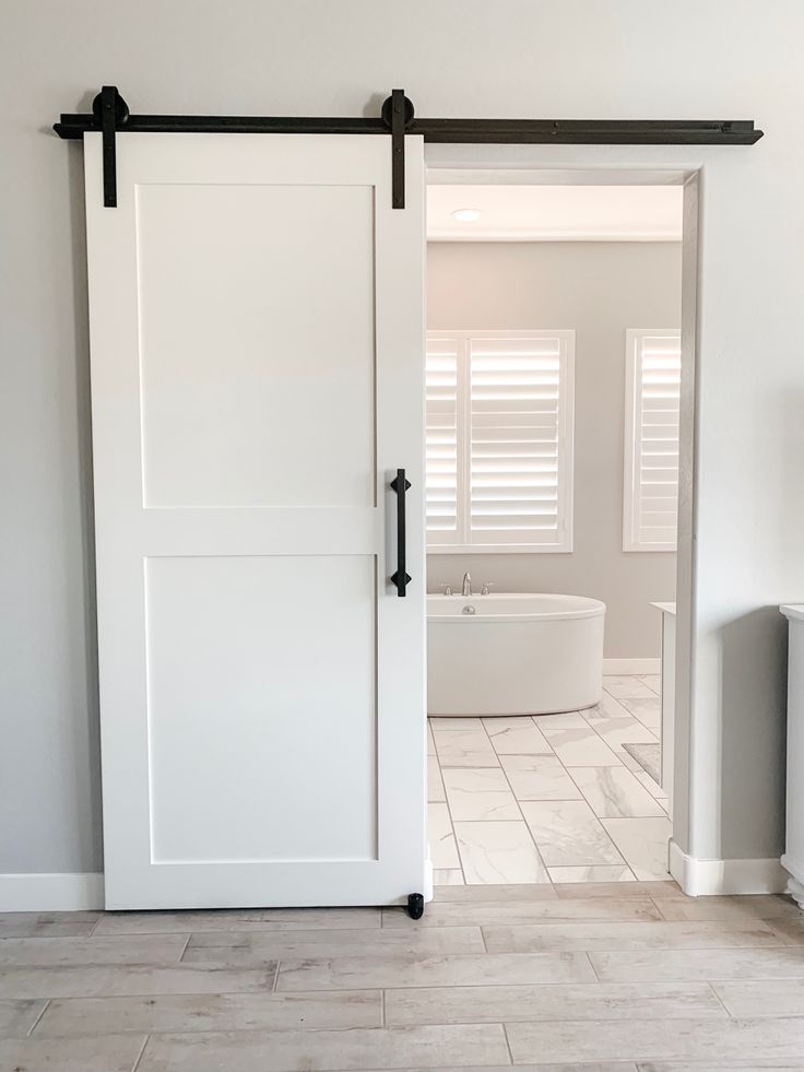 an open sliding door in a white bathroom