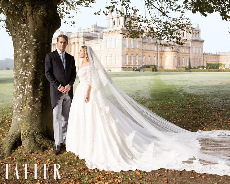 a bride and groom standing next to a tree