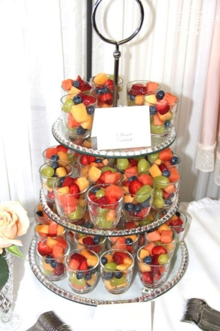 a tiered tray filled with fruit on top of a table