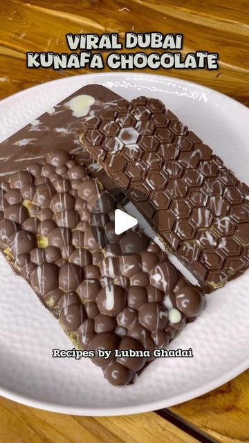 two pieces of chocolate on a plate with the words virtual dubai kunnafa chocolate