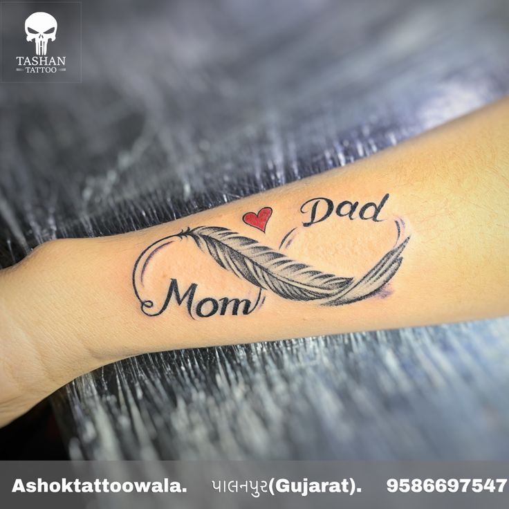 a woman's arm with a tattoo that says dad and a feather on it