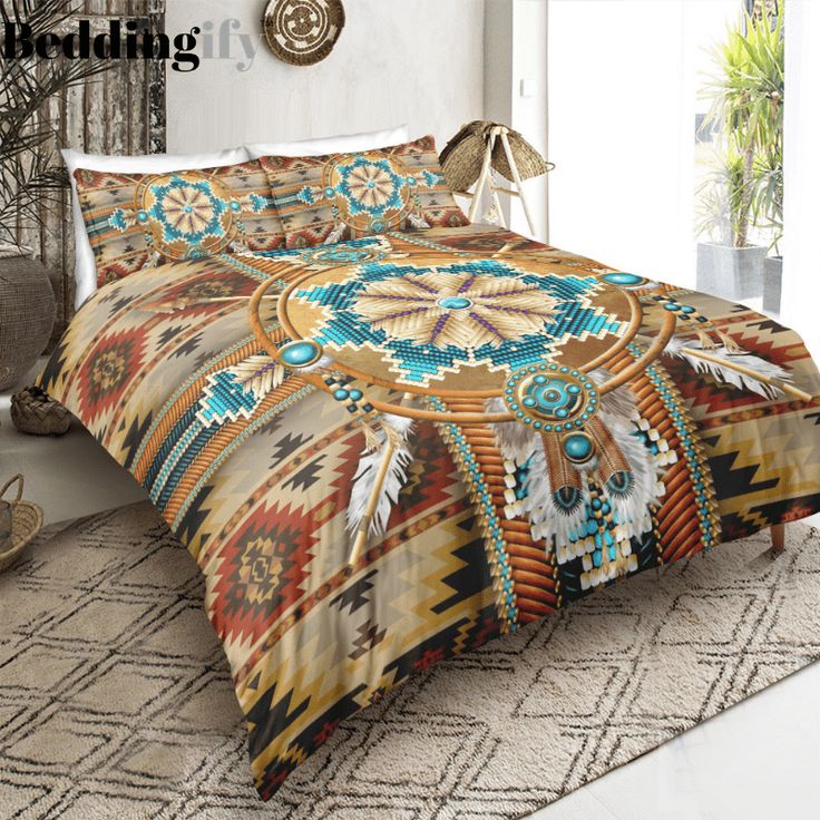 a bed with a colorful comforter on top of it next to a plant in a room