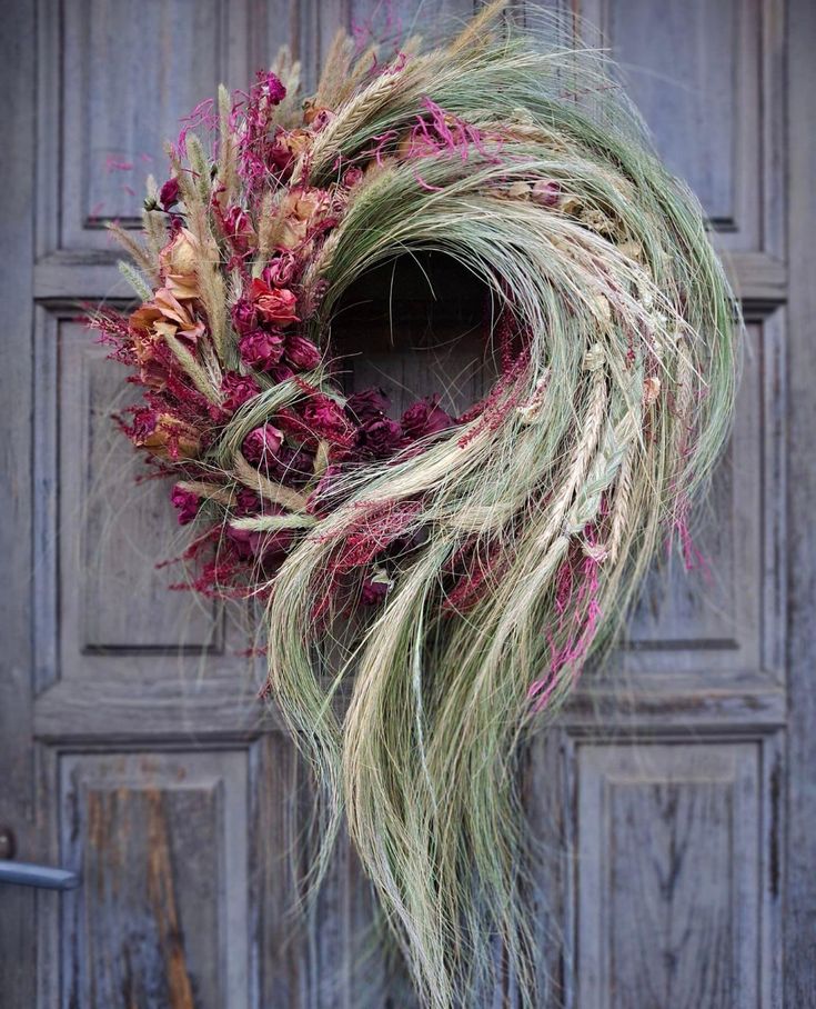 a dried wreath is hanging on the front door